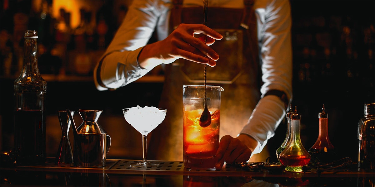 Premium Photo  Barman pours a cocktail into a shaker cocktail making and  mixology